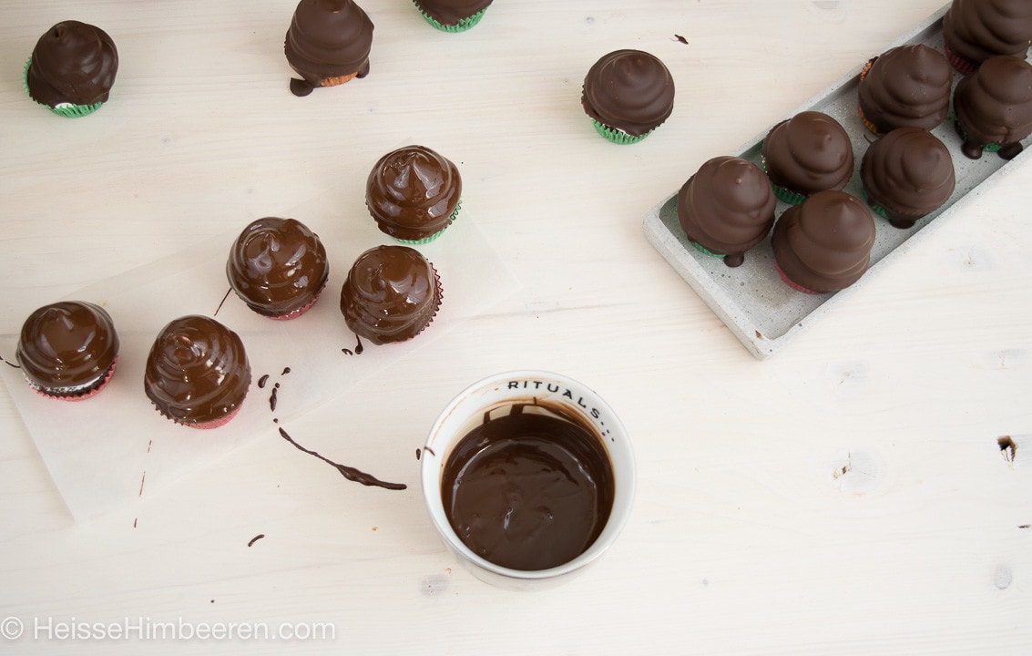 Schokokuss Cupcakes werden in Schokolade getaucht