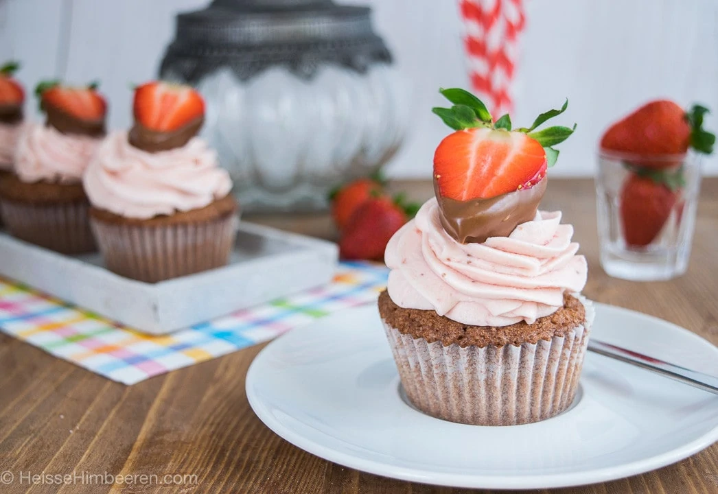 Ein Erdbeer Cupcake mit einer halben Erbeere 