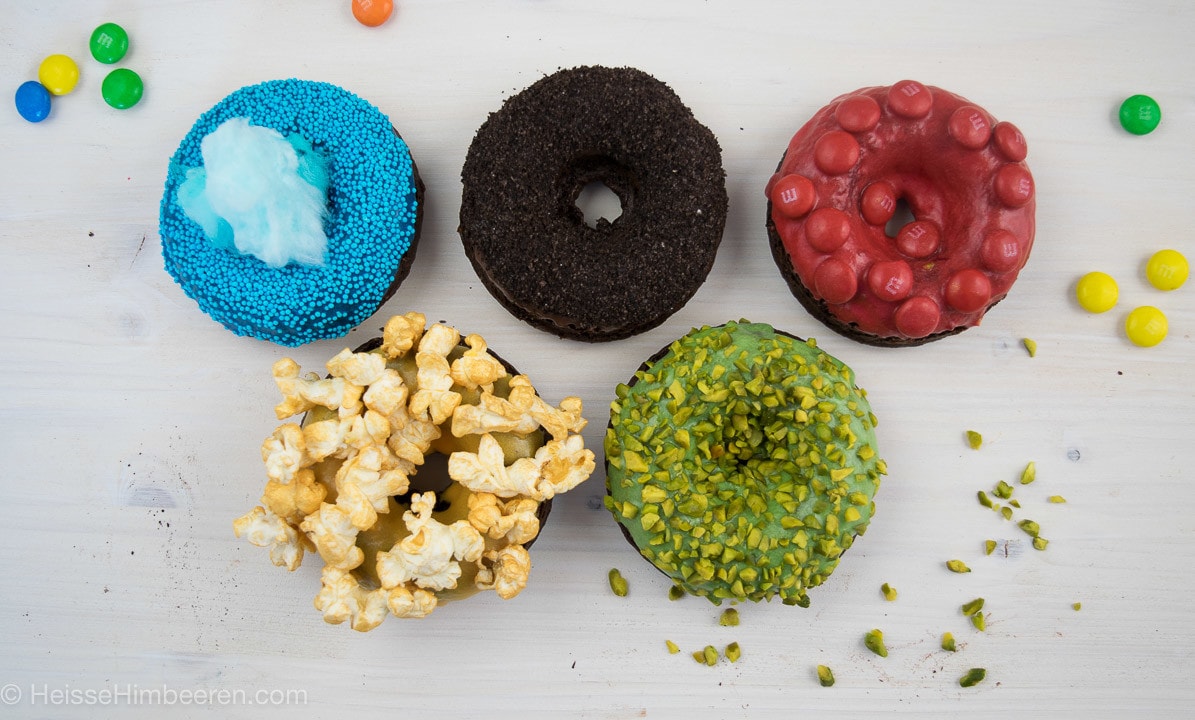 Fünf Donuts mit unterschiedlichen Donut Toppings. Von Popcorn zu Smarties bis hin zu Pistazien