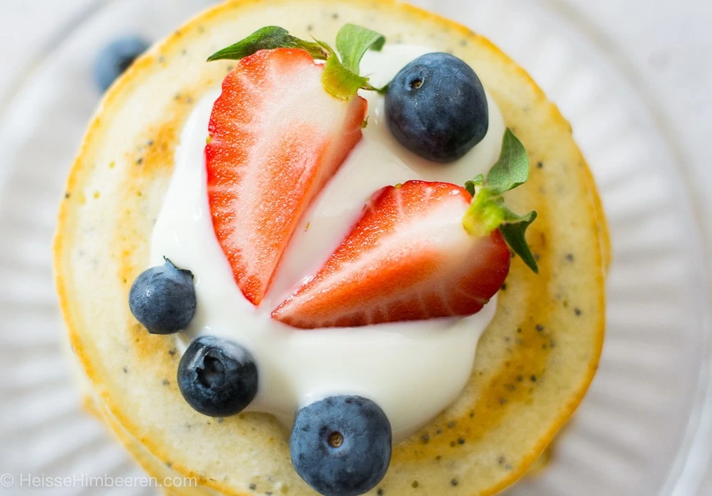 Ein Zitronen Pancake von oben mit Joghurt, Blaubeeren und Erdbeeren