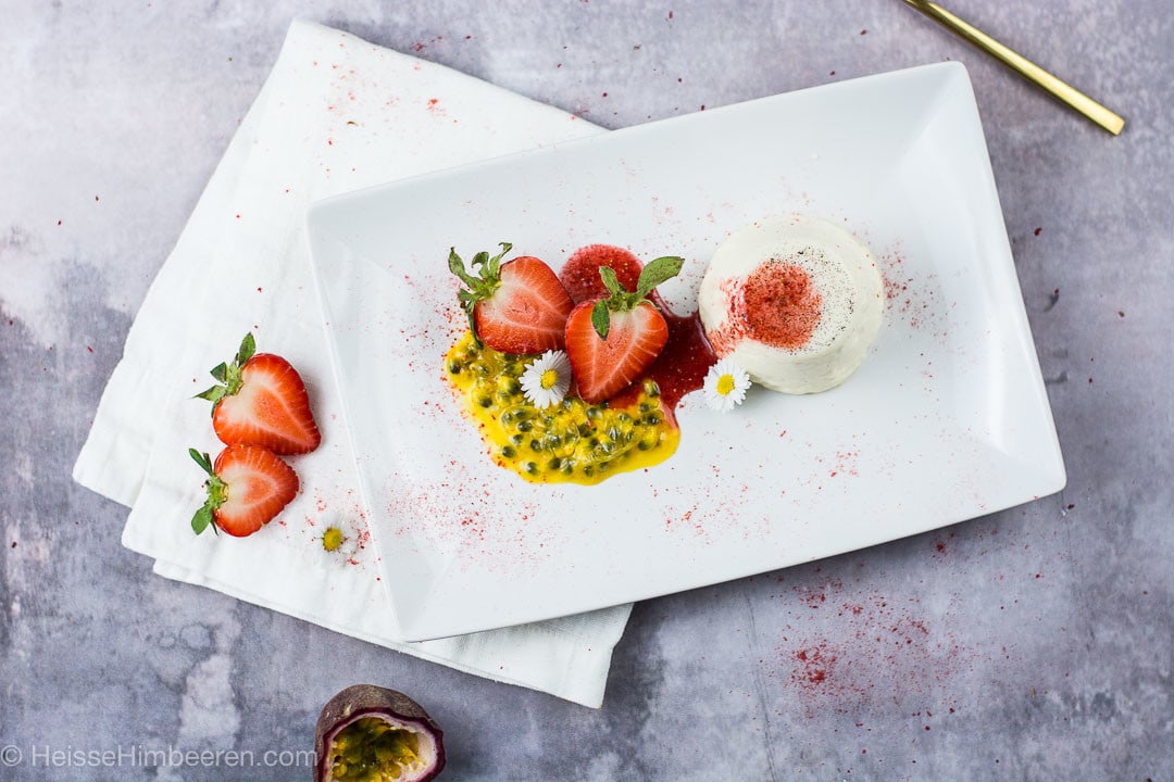 Ein Panna Cotta mit Erdbeersauce auf einem weißen Teller
