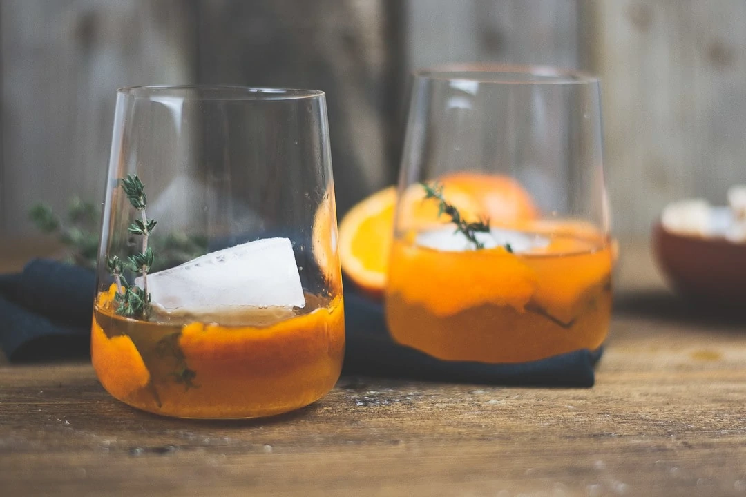 Zwei Old Fashioned mit Mandarine & braunem Rum im Cocktails Glas.