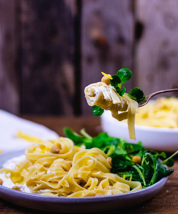 Closeup einer Gabel mit Pasta, Ricotta und Feldsalat