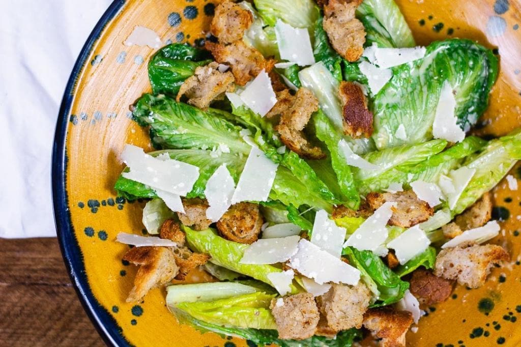 Ein Caesar Salad in einer gelber Schüssel