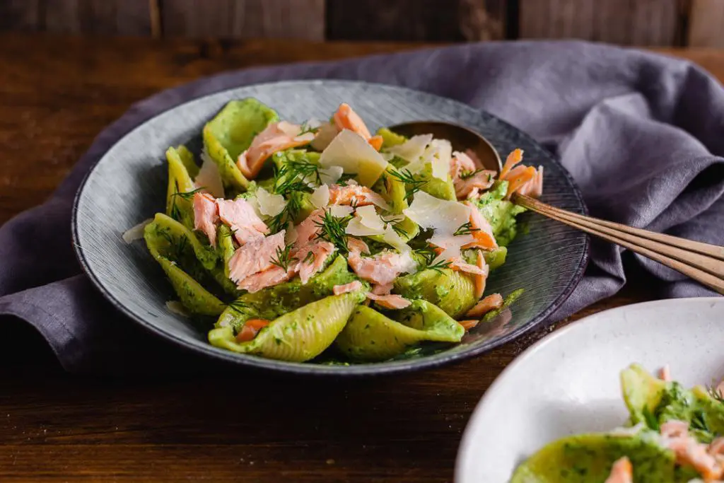 Ein Löffel in einem Teller mit Nudeln und Lachs