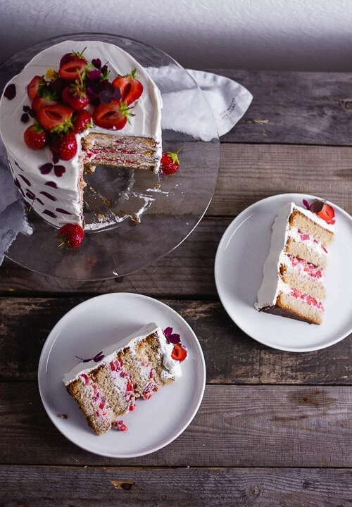 Ein Stück Erdbeer Geburtstagskuchen auf einem weißen Teller.