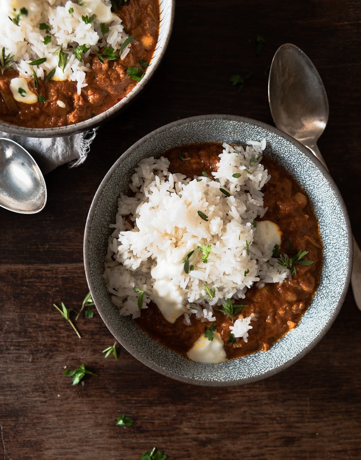 Das einfache Kichererbsen Curry mit Reis in einem tiefen Teller mit Löffel.