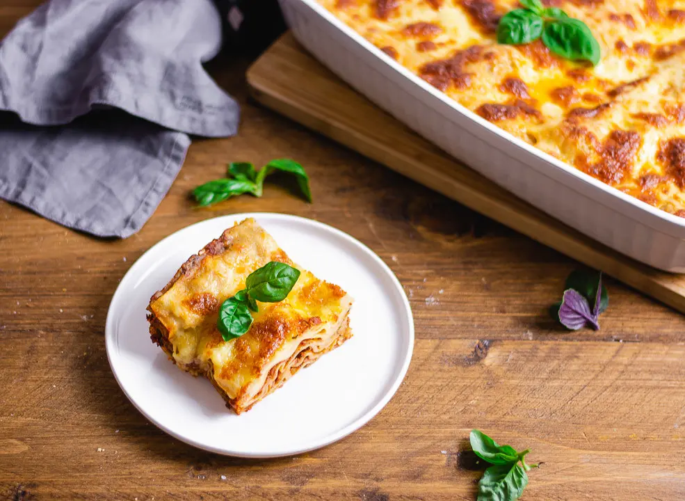 Eine vegetarische Lasagne Bolognese und Basilikumblätter