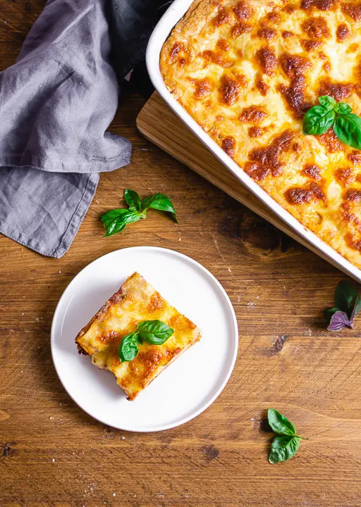 Ein Stück italienische Lasagne mit viel Käse auf einem Teller