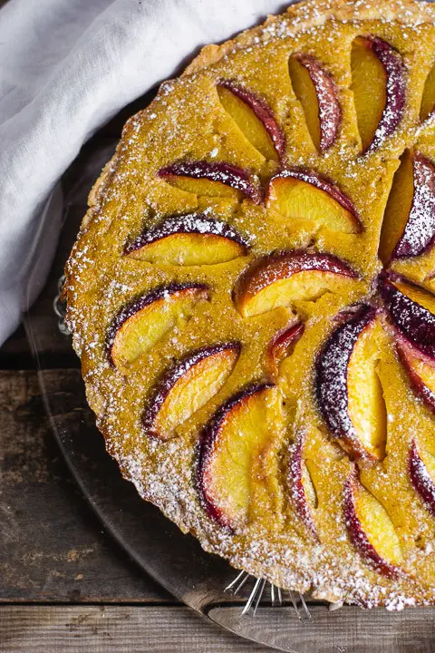 Der Pfirsichkuchen in der Nahaufnahme. Es wurde Puderzucker über den Kuchen gestreut
