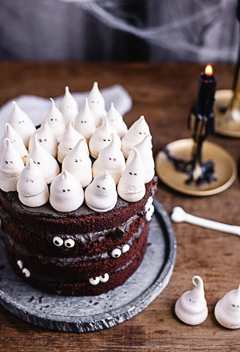 Zwei brennende schwarze Kerzen neben der Halloween Torte