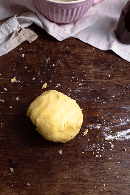 Aus der rehobelten Butter entsteht der Mürbeteig. Der Mürbeteig wird zu einer Kugel geformt und darf ruhen.