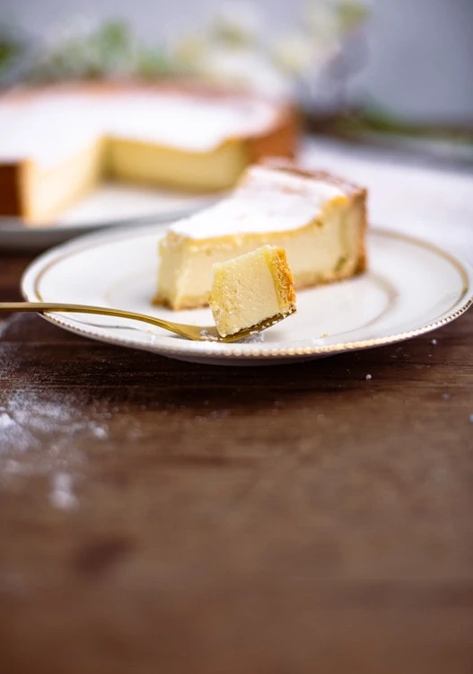 Das Bild zeigt, wie cremig des Käsekuchen Rezept ist. Ein Stück des Käsekuchens liegt auf einer Gabel. Die saftige, cremige Textur ist gut zu erkennen. 