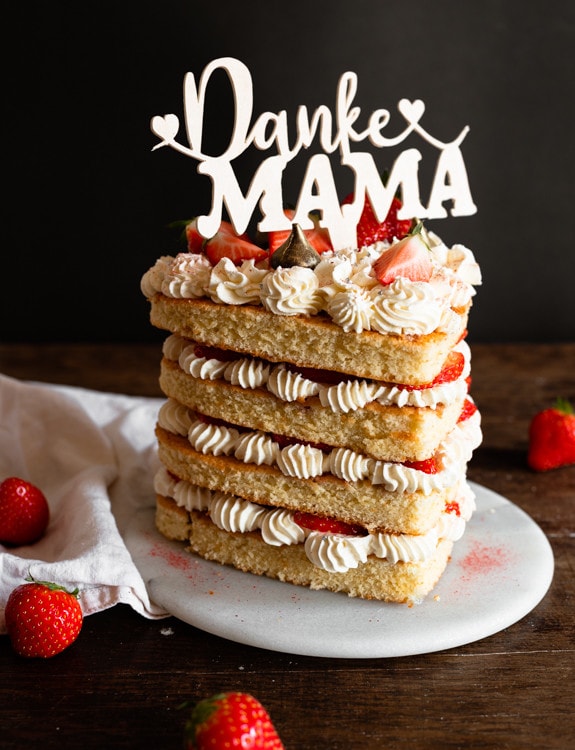 Muttertagstorte mit Erdbeeren und Cake Topper auf dem steht "Danke Mama".