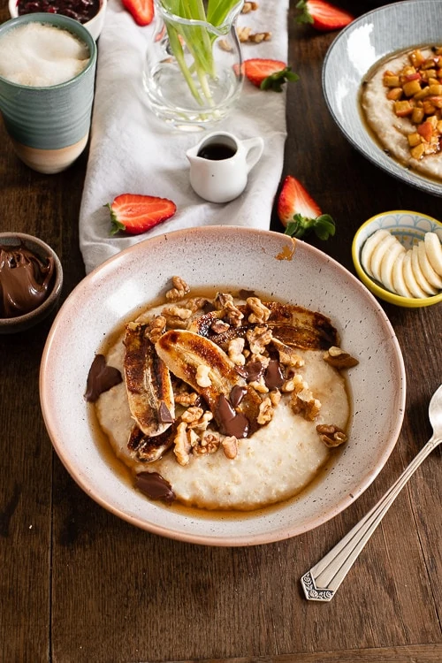 Der Porridge ist mit karamellisierter Banane, Walnüssen und Schokosplittern garniert. 