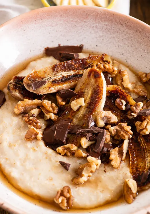 Karamellisierte Bananen sind das Topping dieses Porridges. Durch die Zeit in der Pfanne bekommen die Bananen eine tolle, goldene Farbe. Walnüse und Schokosplitter sind tolle Begleiter der Banane.