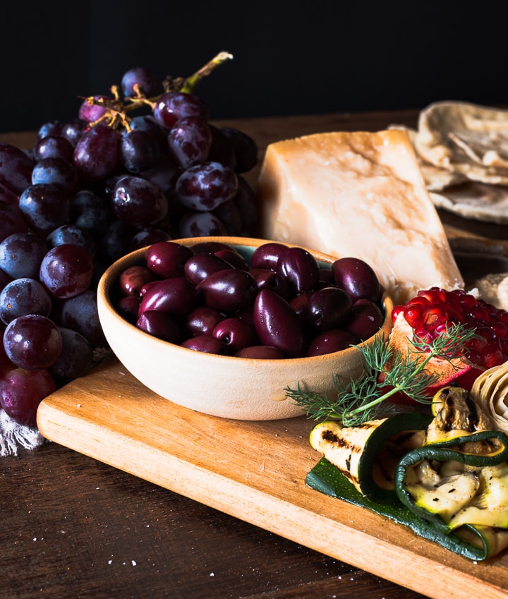 Oliven, Parmesan und Weintrauben auf einer Antipasti Platte. 