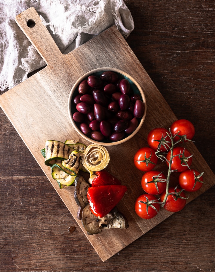 Oliven, gegrilltes und eingelegtes Gemüse und Tomaten sind tolle Elemente für eine Antipasti Platte 
