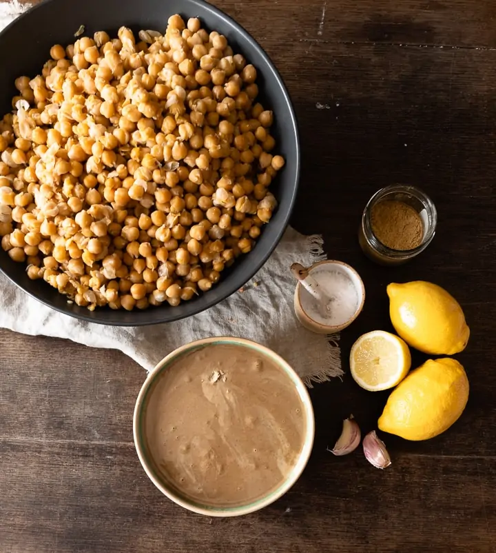 Die Zutaten für den Hummus sind weich gekochte Kichererbsen, Tahini, Kreuzkümmel, Zitronensaft, Salz und Knoblauch. 