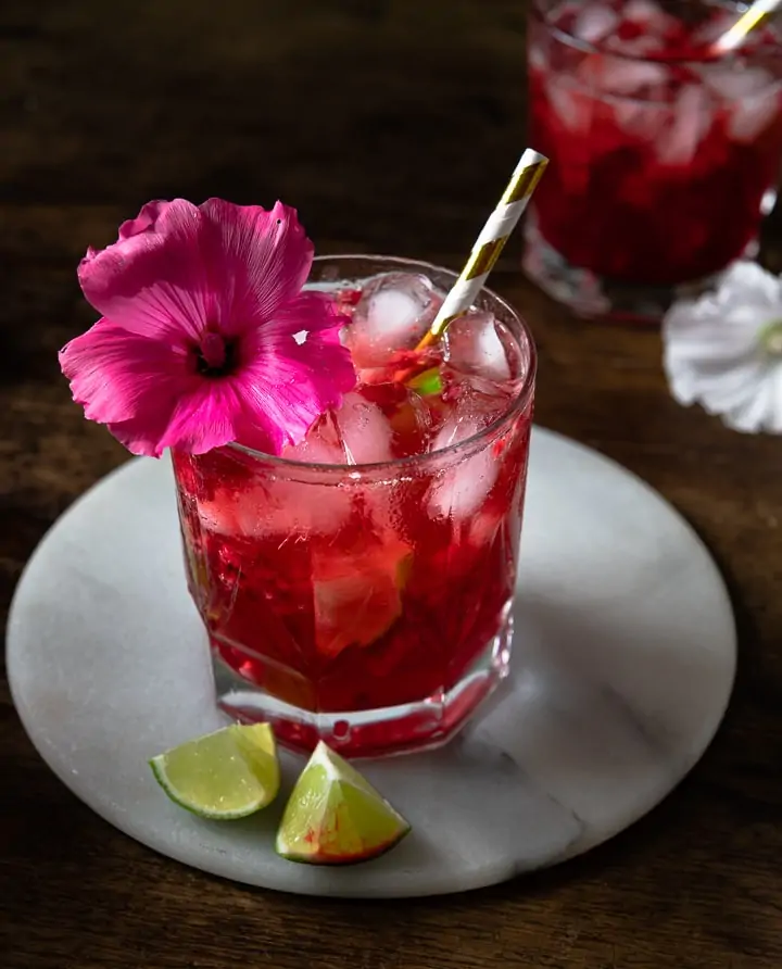 Ein Hibiskus Cocktail mit einer Blume und einen Strohhalm.