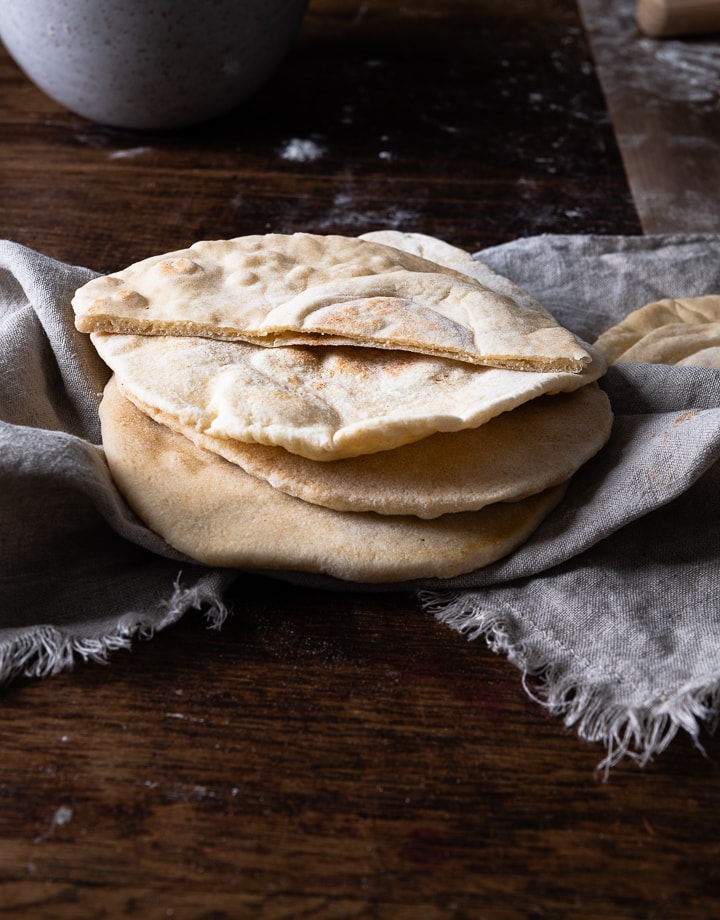 Pita Brot selber machen ist nicht schwer. Es liegen drei auf dem Tisch.