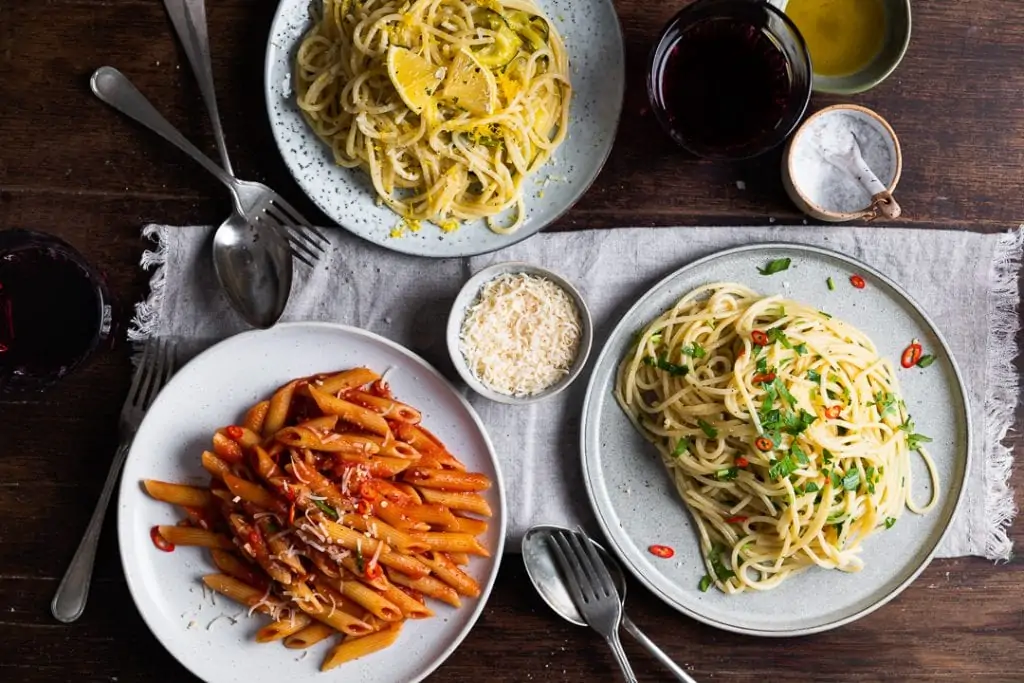 Eine Spaghetti Aglio e Olio, einmal Penne Arrabiata und Zitronennudeln auf dem Tisch. 