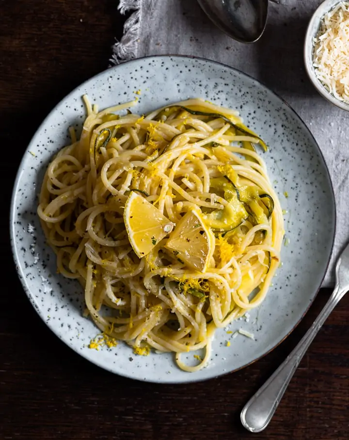Ein Teller Zitronen Spaghetti mit Zucchini und einer Gabel.