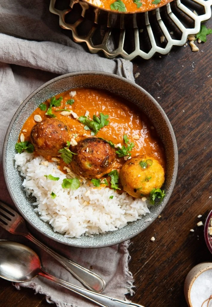 Das indische Malai Kofta Curry, daneben liegen Gael und Löffel.