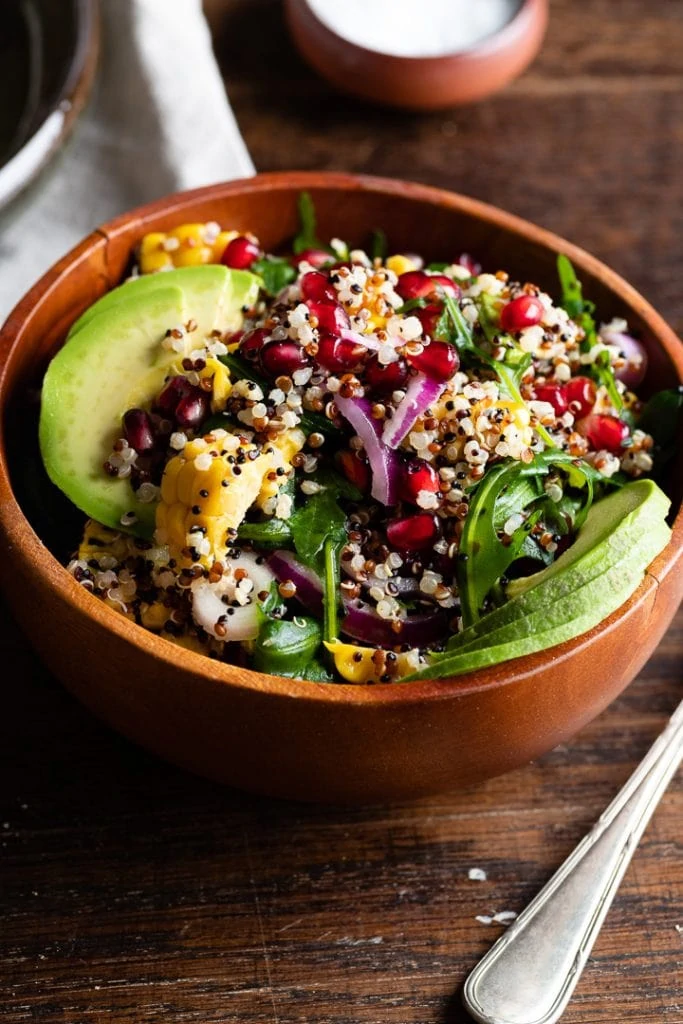 Ein gesunder Quinoa Salat in einer Holzschüssel auf dem Tisch.