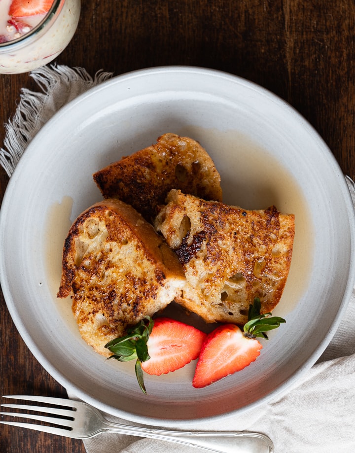 Süße French Toast mit Ahornsirup und Erdbeeren liegen auf dem Teller.