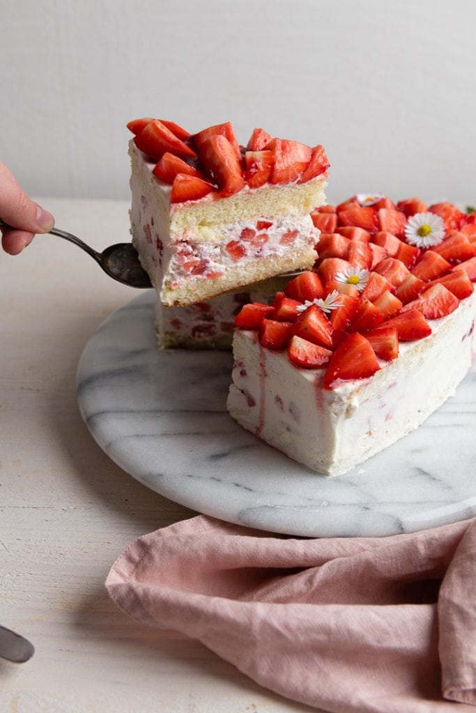 Ein Stück Erdbeer Vanille Kuchen mit Quark wird serviert.