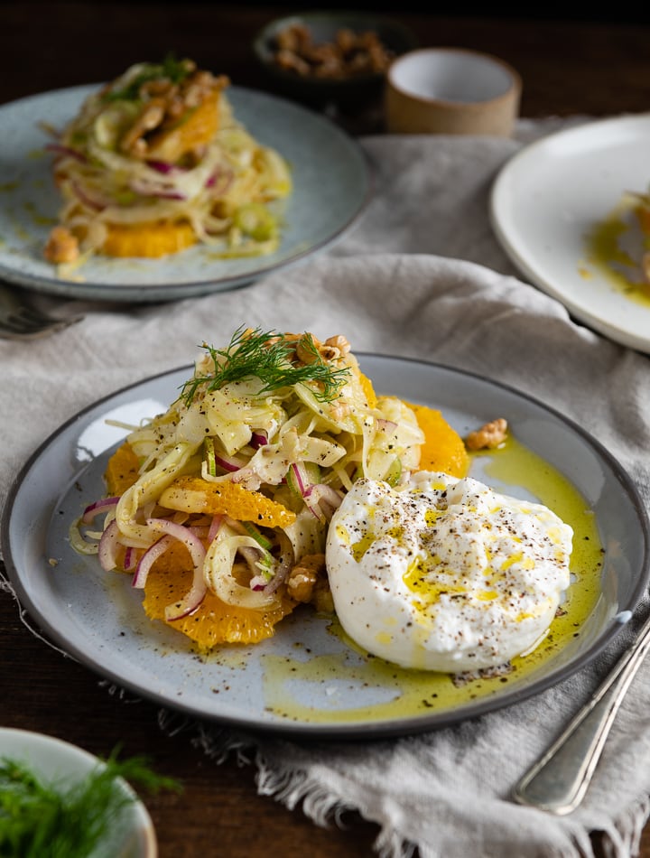 Neben dem Fenchelsalat mit Orangen und Walnüssen, liegt ein Burrata.