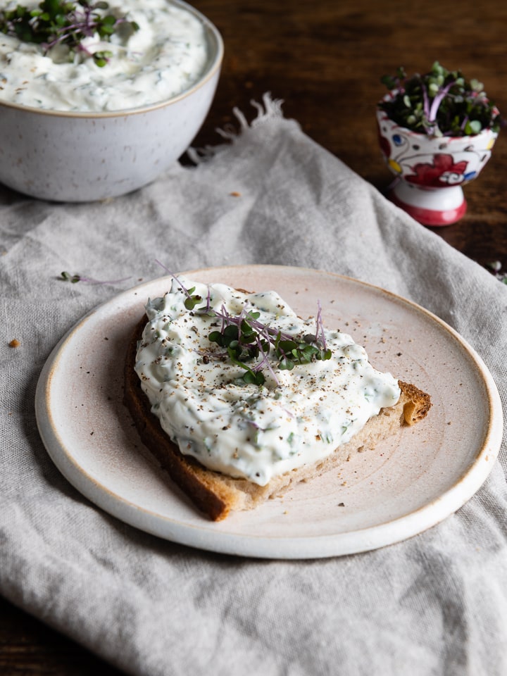 Kräuterquark dip auf einer Scheibe brot.