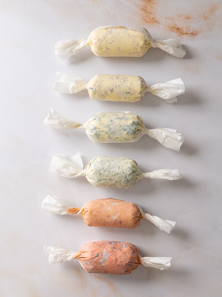 Alle sechs selbst gemachten kräuterbutter nebeneinander.