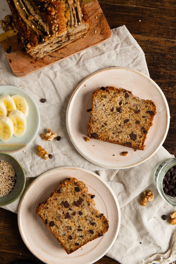 Zwei Stücke saftiges bananenbrot auf zwei tellern.