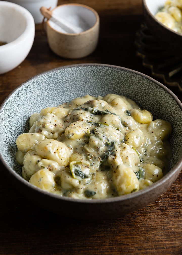 Gnocchi mit gorgonzola und spinat in einem tiefen Teller.