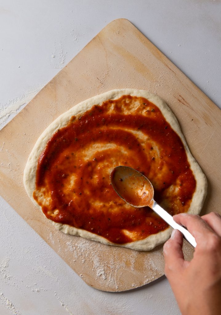 Pizza mehl liegt unter der Pizza, sodass sie gleich leicht in den Backofen gleiten kann.