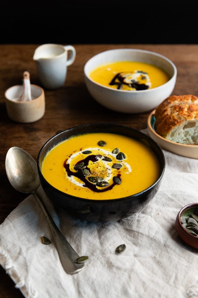 Eine kürbissuppe mit kartoffeln und möhren auf dem Tisch.