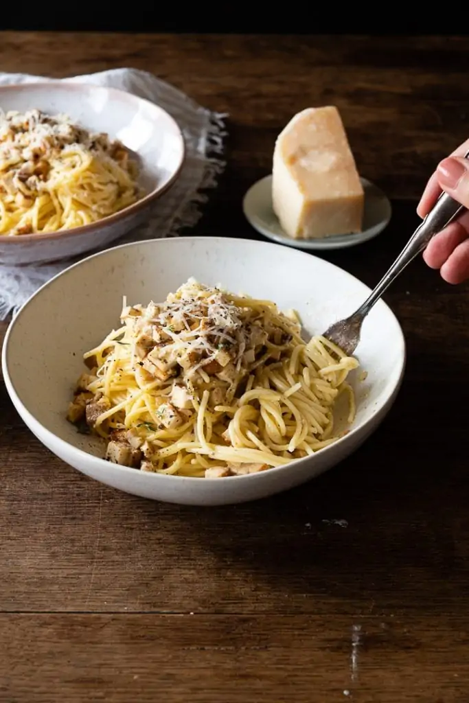 Vegetarische Spaghetti Carbonara wird auf einer Gabel gerollt.