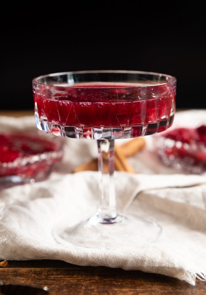 Ein zwetschgenröster im glas mit rotwein angerichtet.