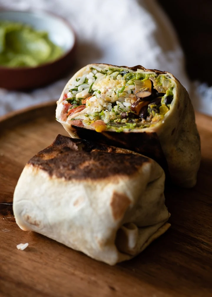 Ein Veggie Burrito auf einem Holzteller.