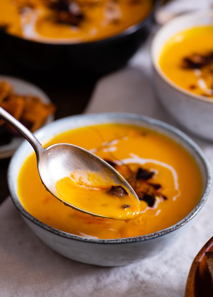 Ein Löffel mit karotten ingwer suppe.