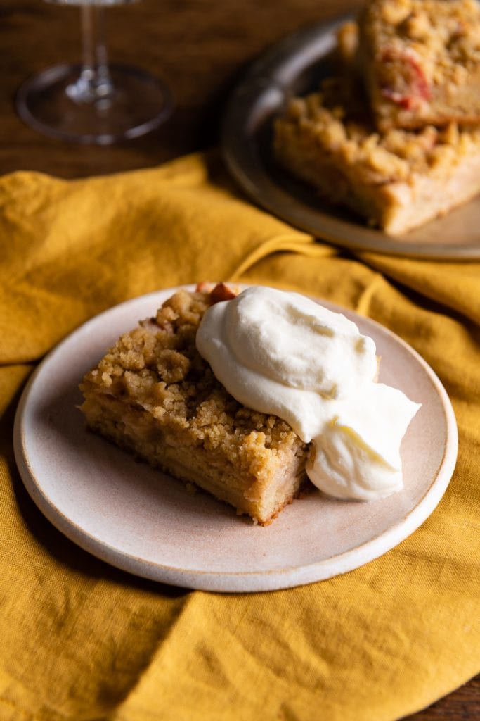 Ein Stück schneller saftiger apfelkuchen vom blech mit Sahne.