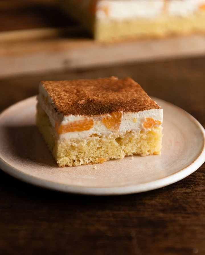 Ein Stück Mandarinen-Schmand-Kuchen auf einem kleinen Teller.