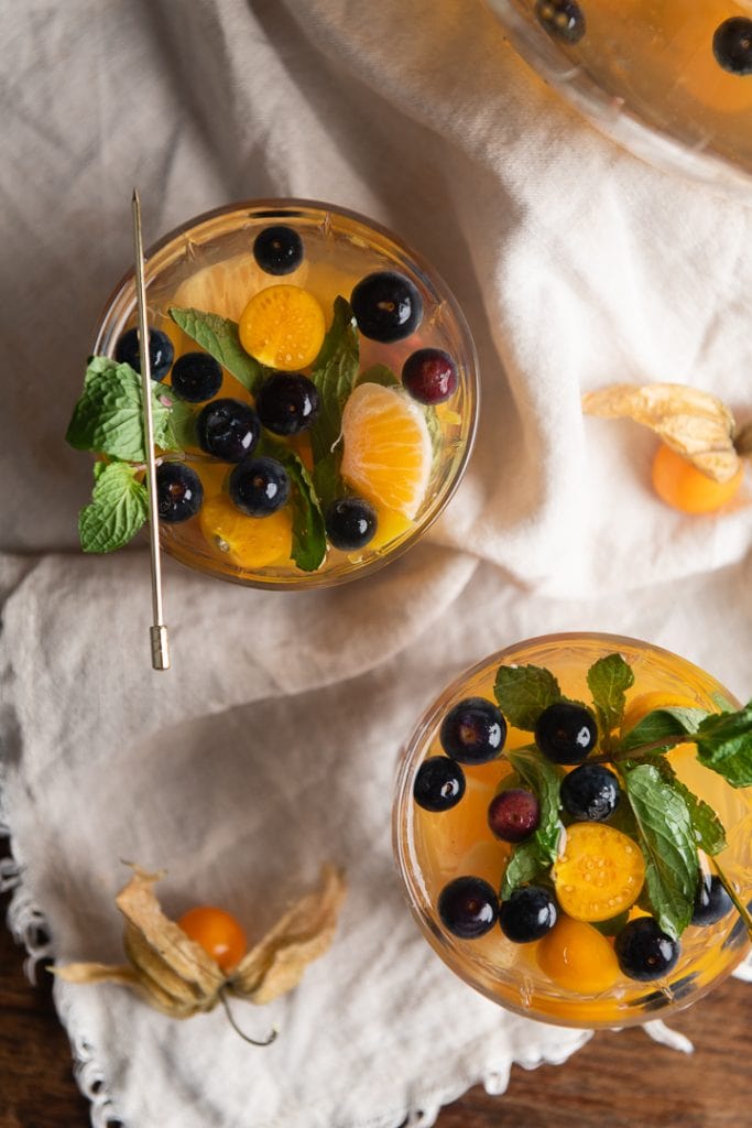 Ein Glas silvester bowle mit früchten auf dem Tisch.