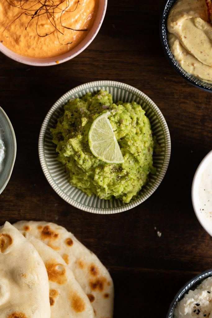 Der fertige Avocado Dip zum Grillen in einer Schüssel auf dem Tisch.

