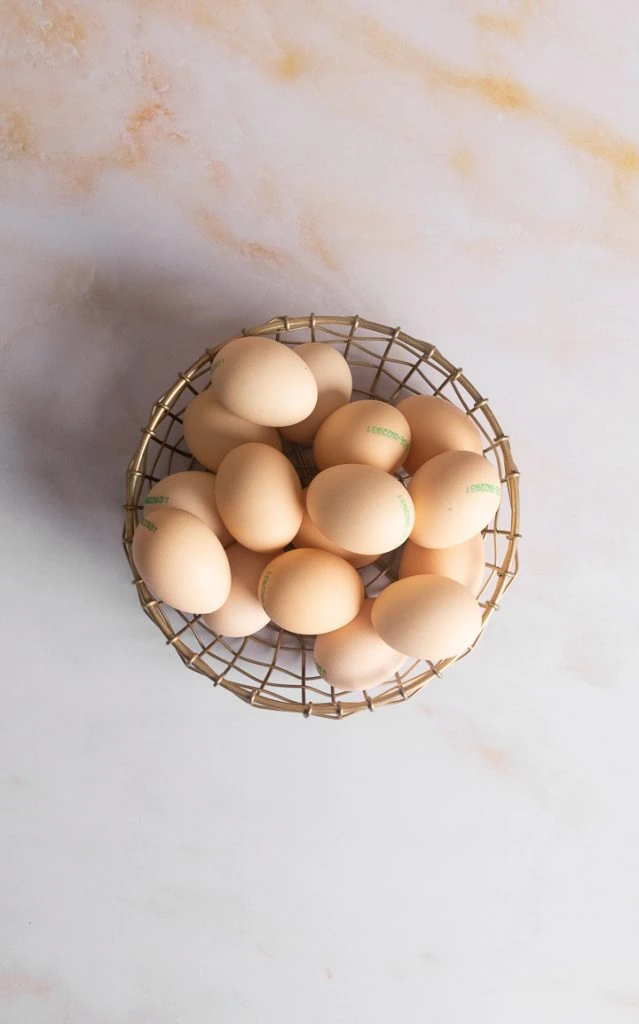 Ein Korb mit Eiern auf dem Tisch.