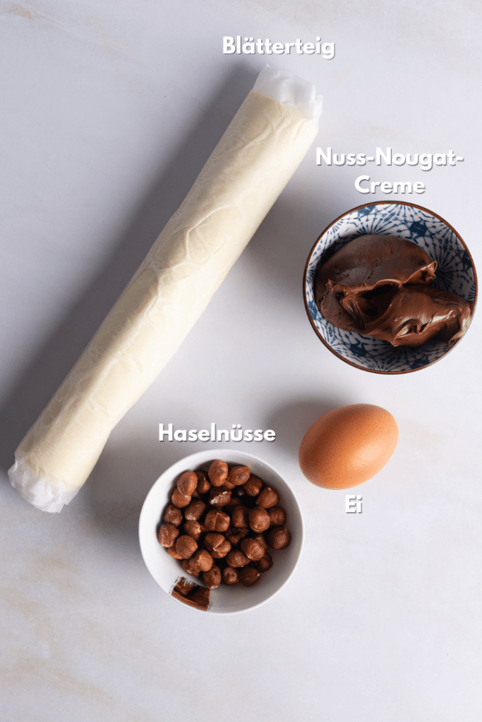 Blätterteig, Nutella, Haselnüsse und Ei sind die Zutaten für das Rezept.