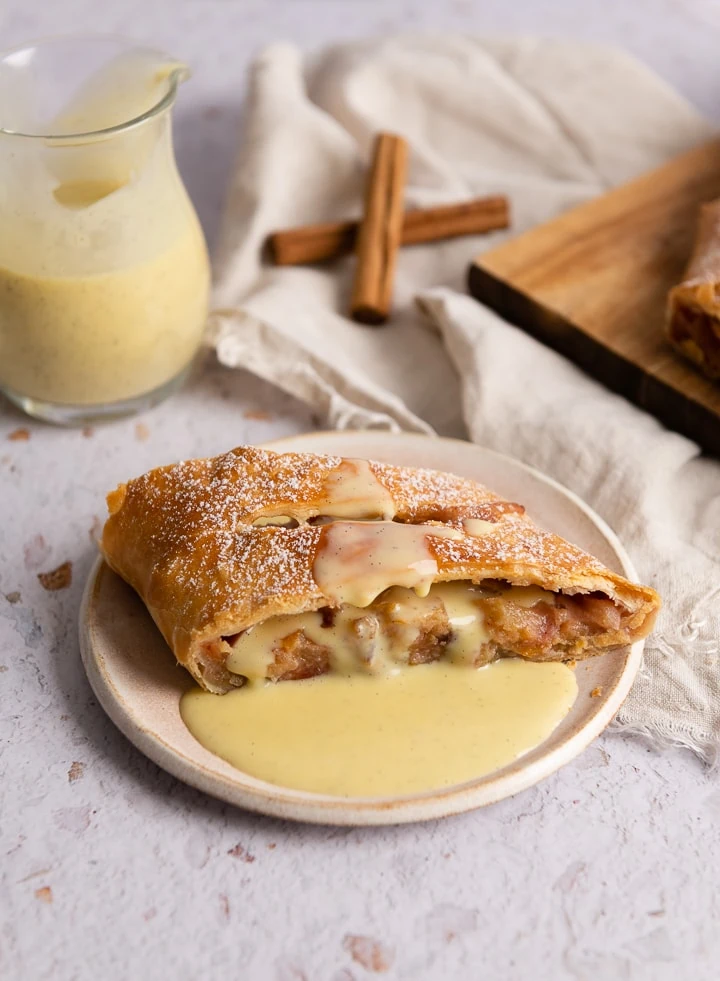 Ein Stück Apfelstrudel mit Vanillesoße.