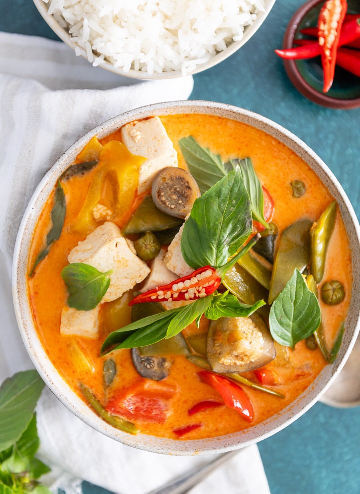 Rotes Thai Curry Rezept von oben auf dem Tisch, daneben liegt ein Löffel.